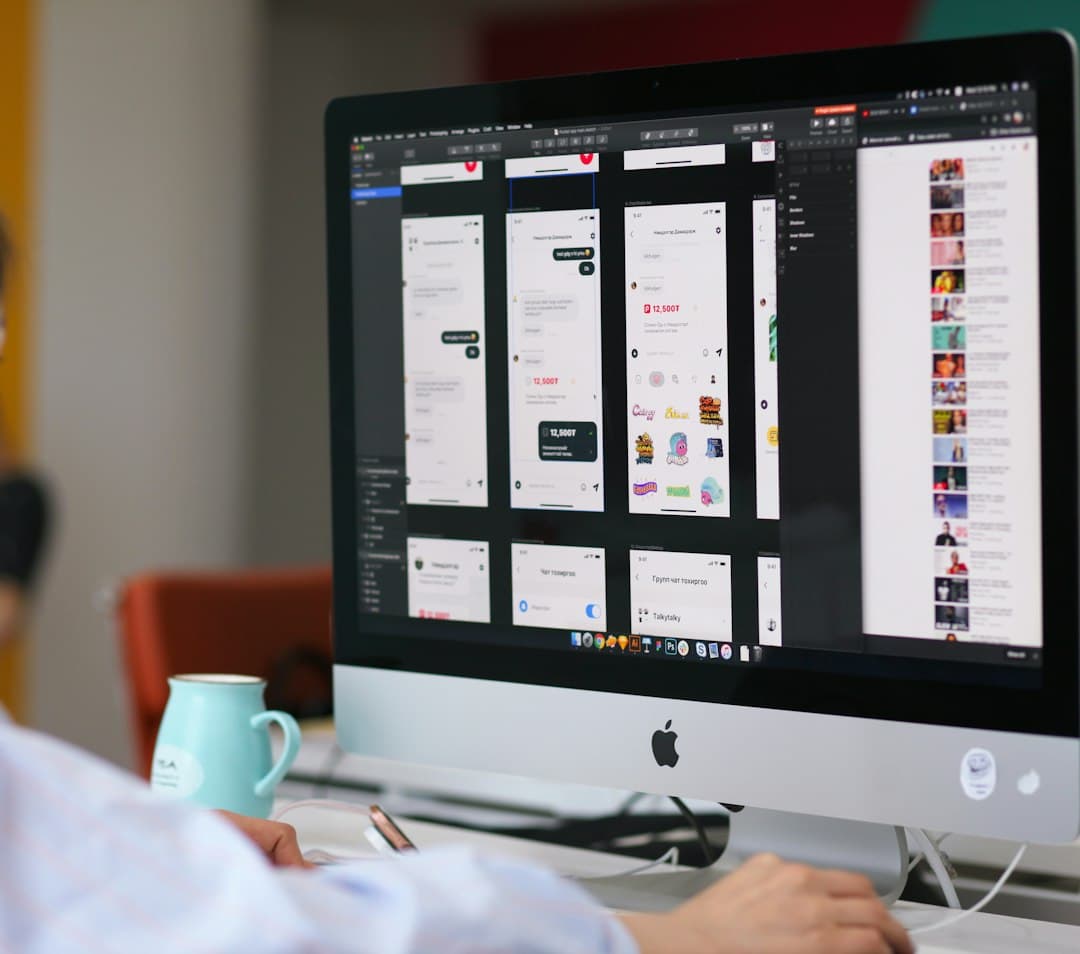 Designer laying out mobile app screens on an iMac